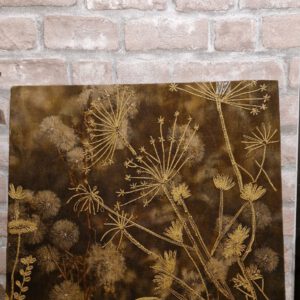 Geborduurd doek met gouden paardenbloemen op donkerbruine stof